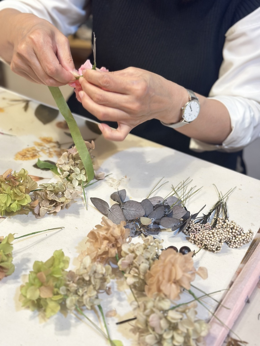 花材を手に取り制作する生徒さまの手元